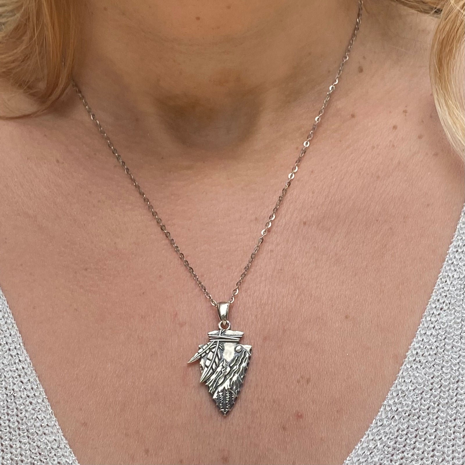Arrowhead necklace sterling silver with detailed feather design worn on a silver chain