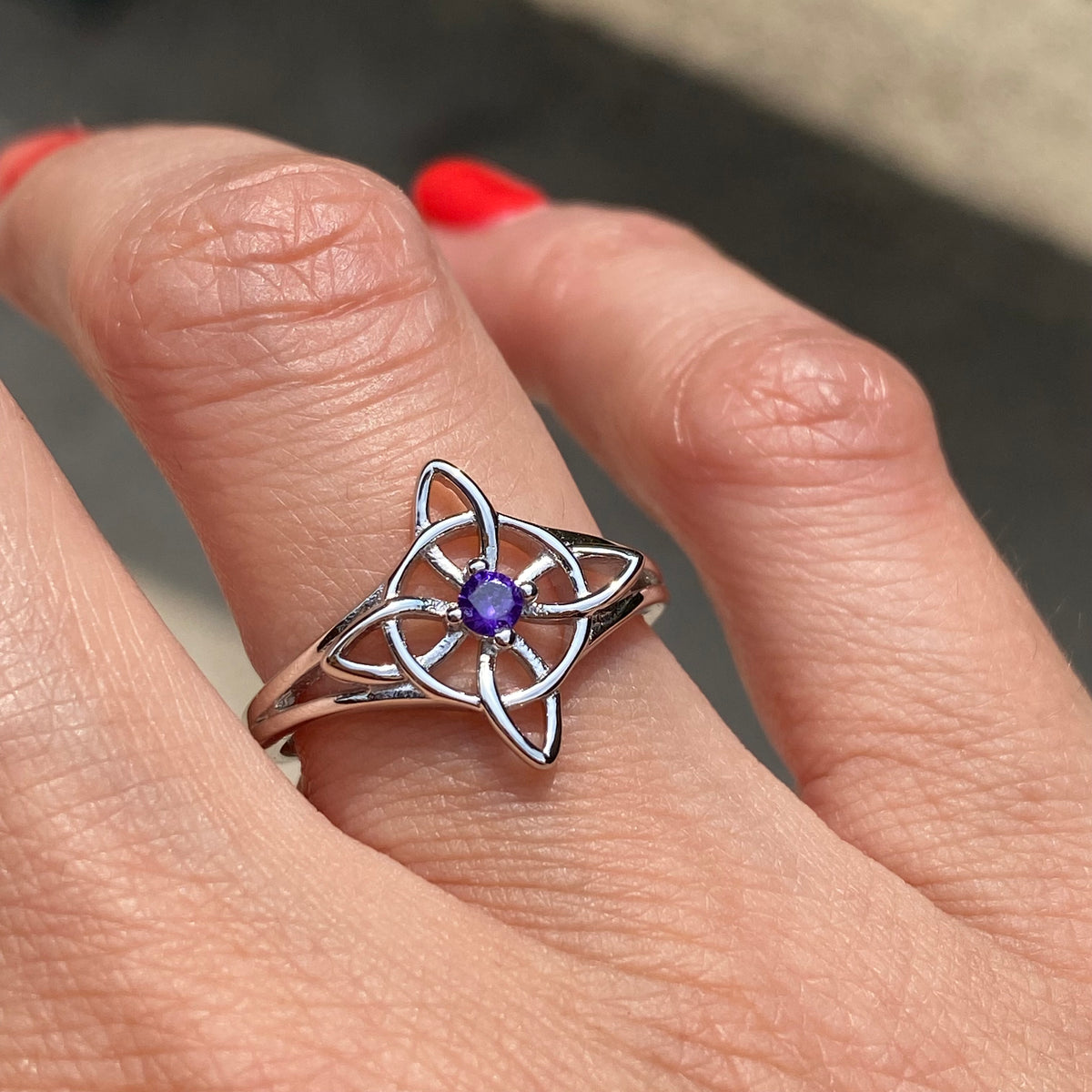 Sterling silver adjustable purple stone Witch knot ring worn on finger showcasing intricate Celtic design