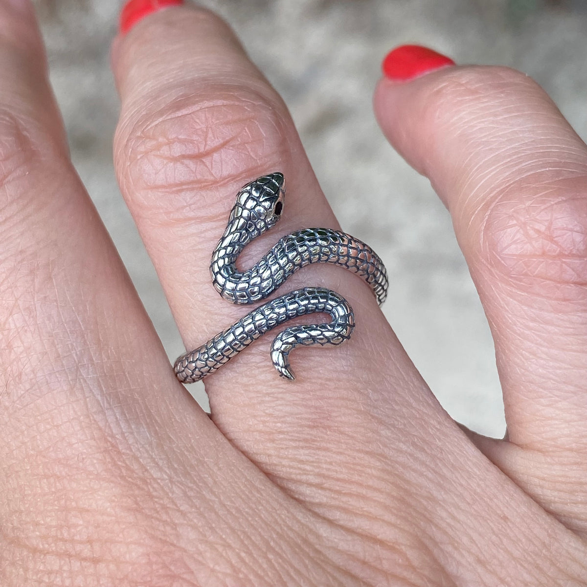 Sterling silver adjustable snake ring worn on finger by Miss Valkyrie with detailed scale design