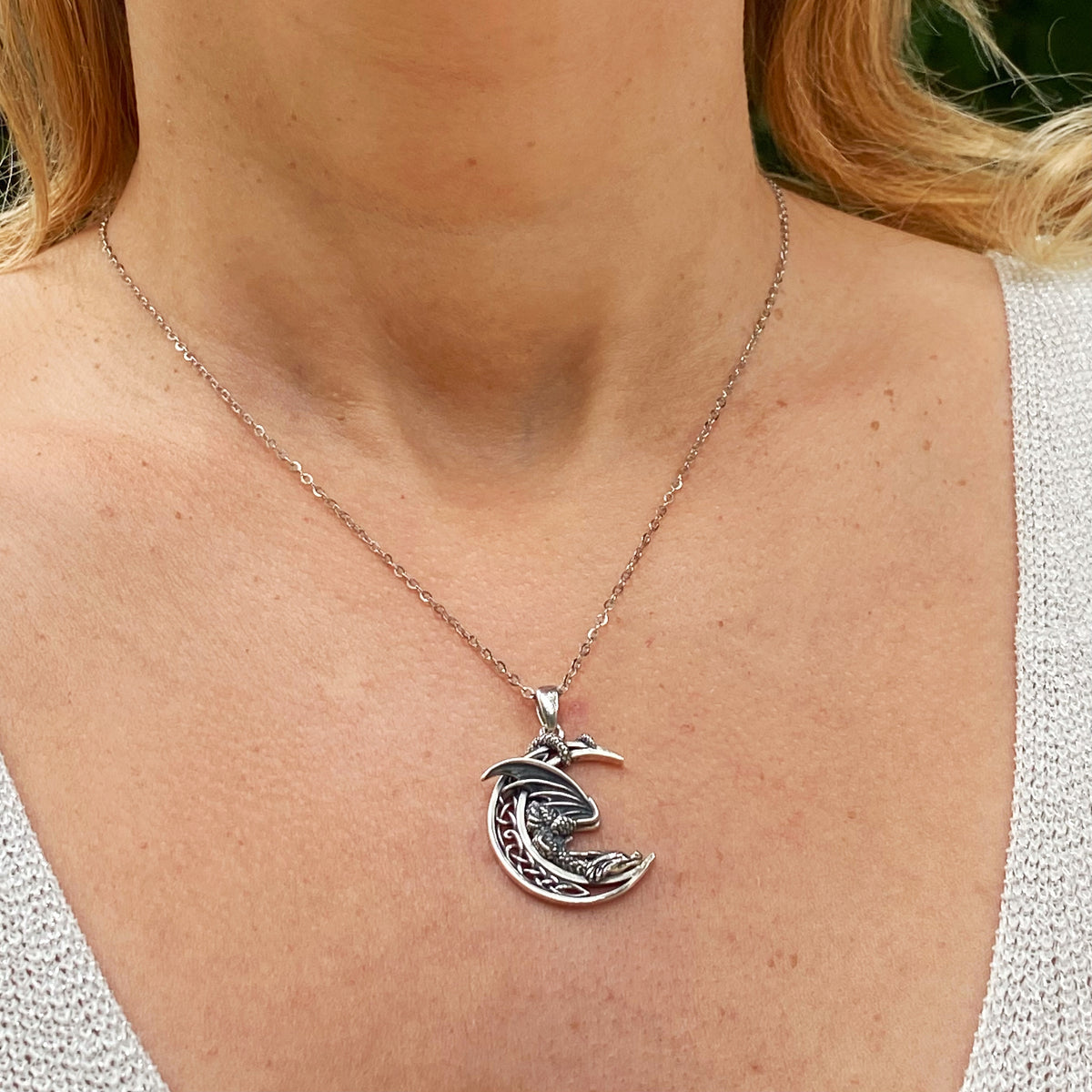 Sterling silver dragon moon necklace worn on a woman with a light knit top by Miss Valkyrie