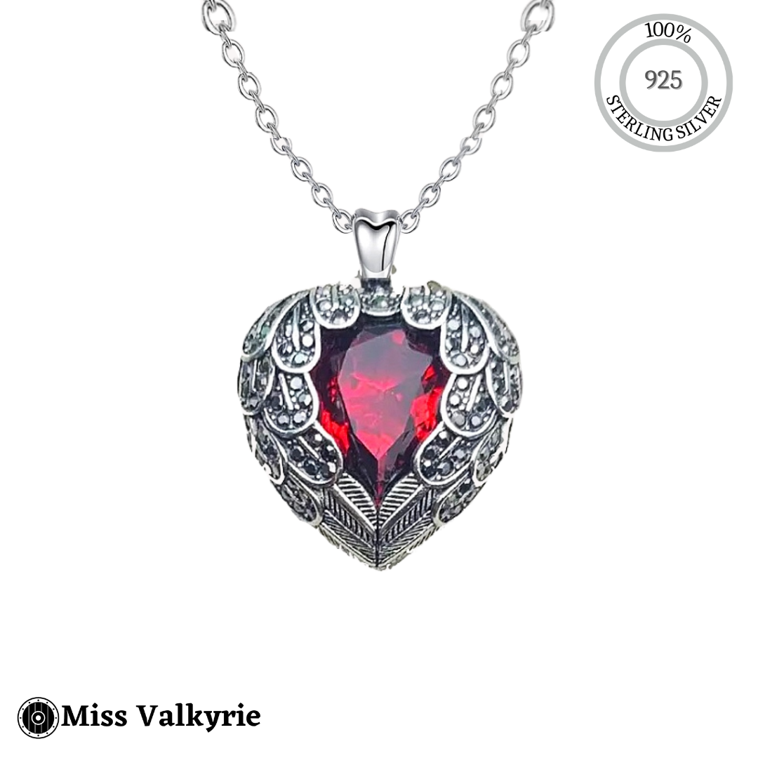 Sterling silver heart wing necklace with red gemstone pendant and intricate feather detailing