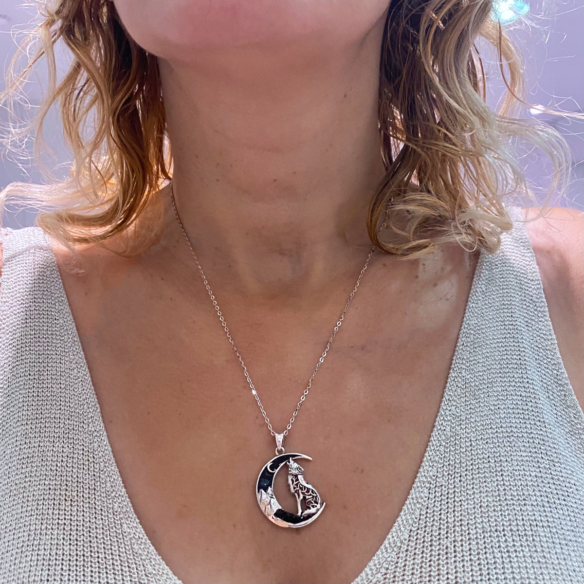 Sterling silver howling wolf necklace moon crescent pendant worn on a silver chain around neck