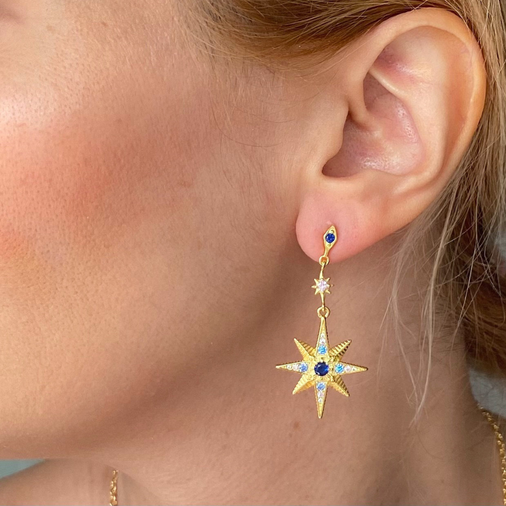 Sterling silver mismatched earrings moon sun gold plated 18k earrings worn on ear with star design and blue accents
