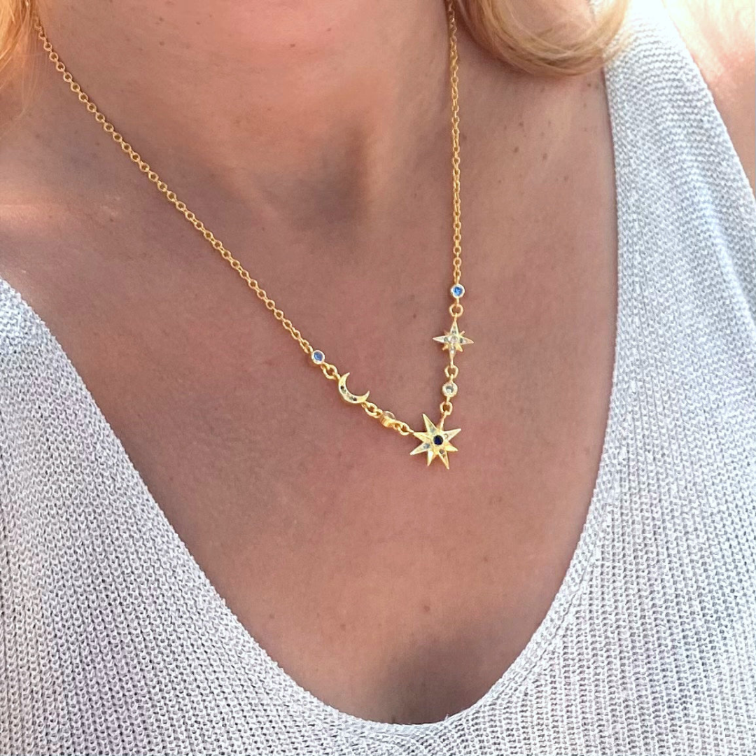 Sterling silver star moon gold plated 18k necklace worn on neckline featuring delicate gold chain and celestial charms