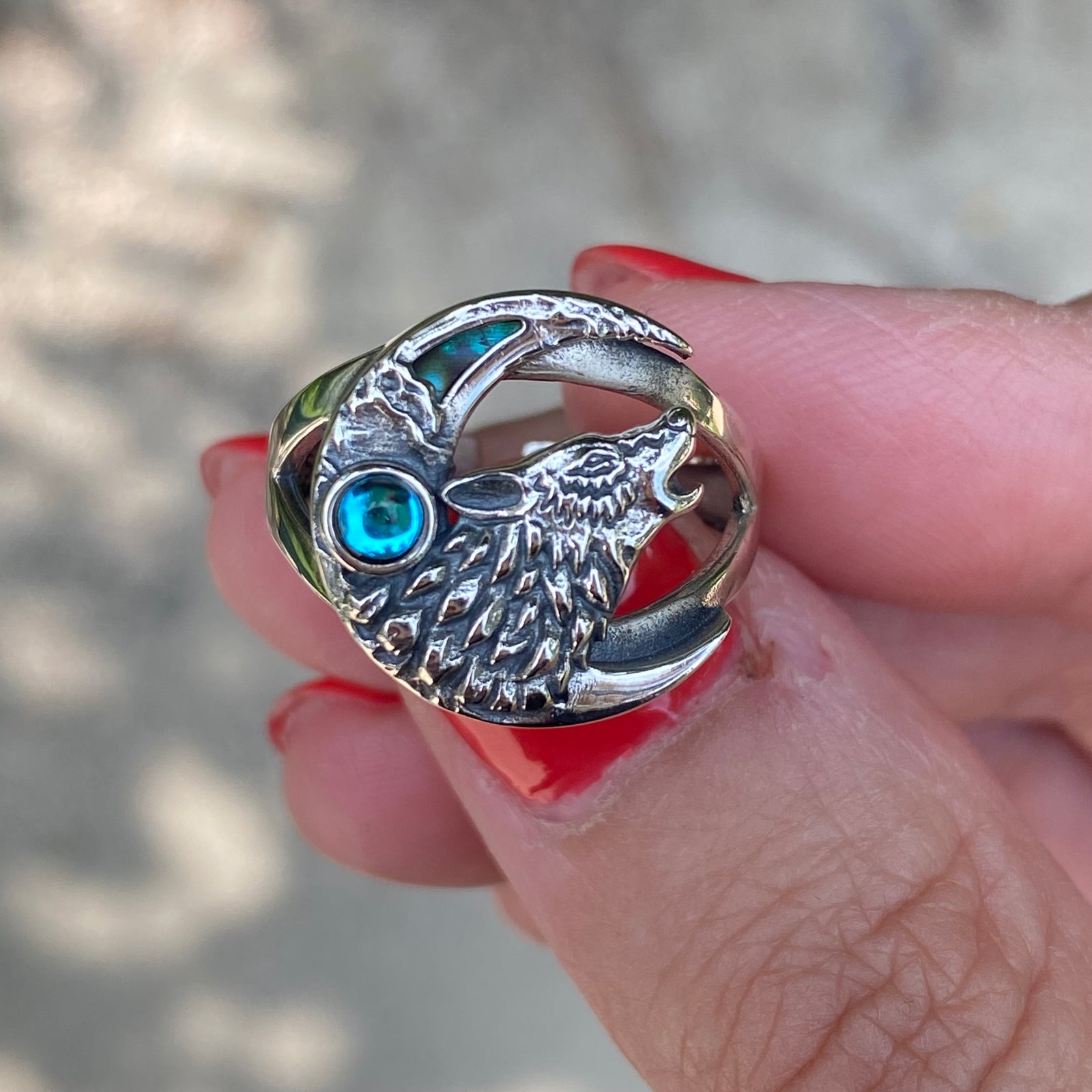 Miss Valkyrie sterling silver wolf ring adjustable with blue gemstone held on hand with red nails