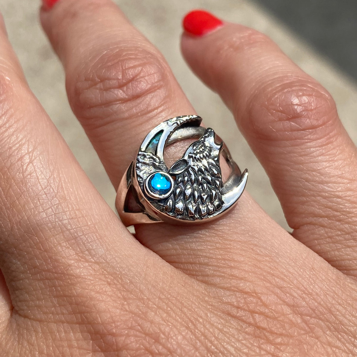 Sterling silver wolf ring adjustable with blue gemstone worn on finger by Miss Valkyrie