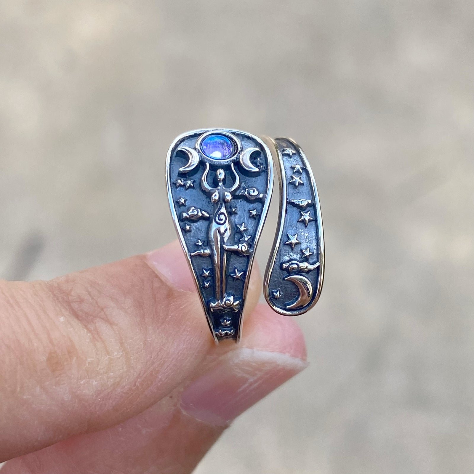 Hekate hecate ring with intricate moon and star designs featuring a glowing gemstone