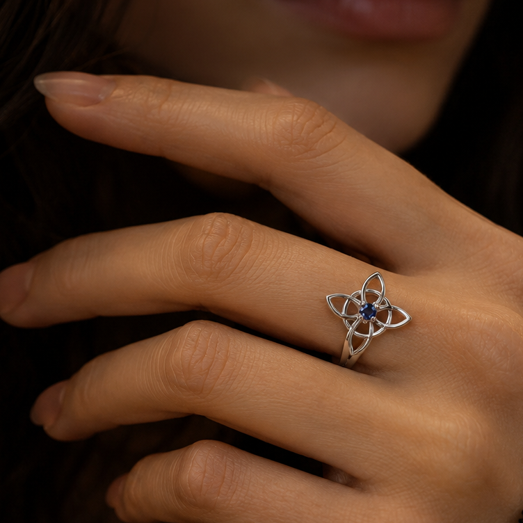 Miss Valkyrie Witch knot ring in silver with a blue gemstone on a model's hand